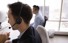 Side view shot of contact center manager man in headphones