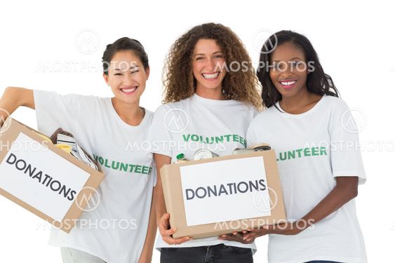 Happy team of volunteers smiling at camera holding donations boxes