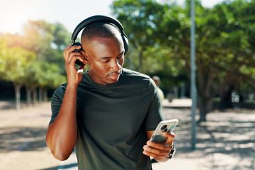 Fitness, headphones and black man on mobile outdoor for...