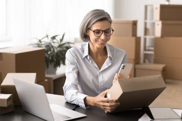 Worker holding mobile phone scanning QR code of retail...