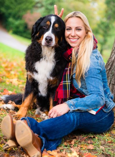 Woman cuddling with dog outside in park