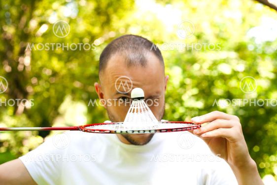Young man winks and covers her face with a racket...