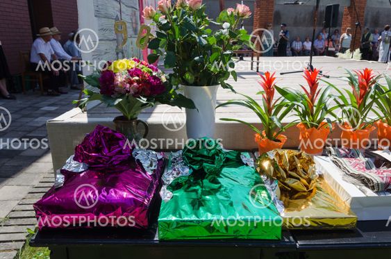 gift in glossy paper and bouquets on table outdoor