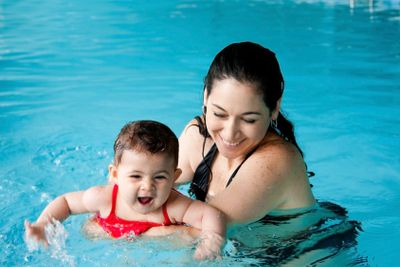 Mother teaching baby swimming