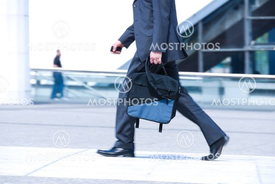 business man holding brief case and walking