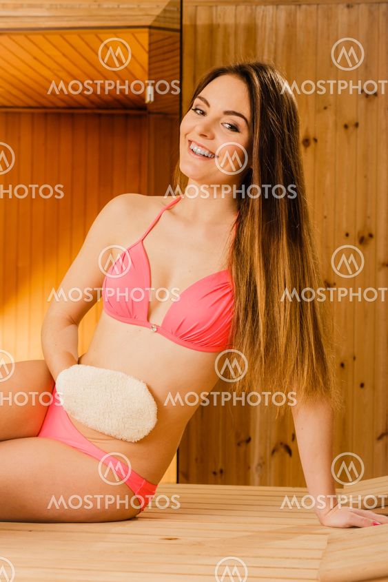 Woman in sauna with exfoliating glove. Skincare.