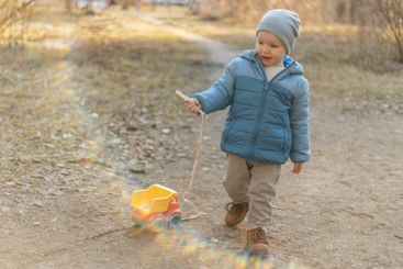 Happy baby child outdoor. Little toddler boy with toy...