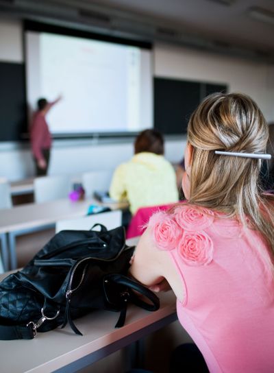 young, pretty female college student sitting in a...
