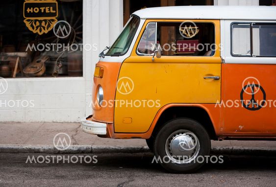 Old orange vehicle in front of hotel