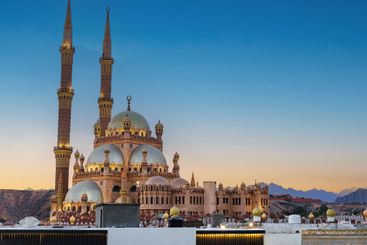 Majestic mosque with tall minarets at dusk in a serene...