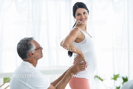 Doctor giving physiotherapy to pregnant woman