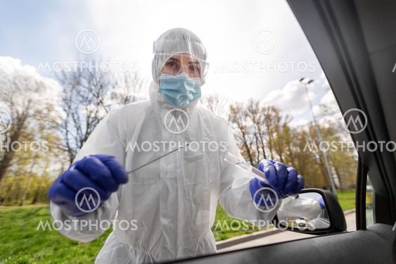 healthcare worker making coronavirus test at car