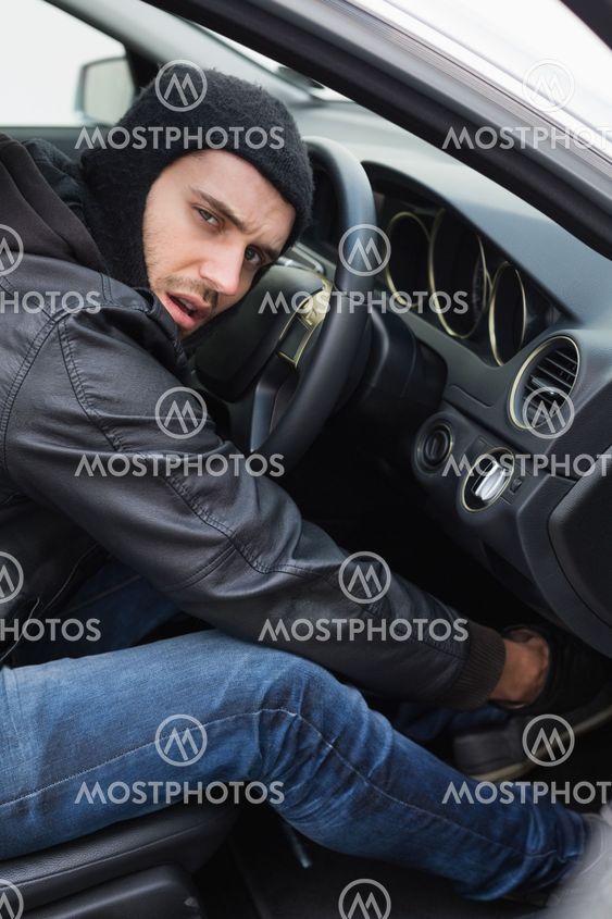 Thief breaking into a car