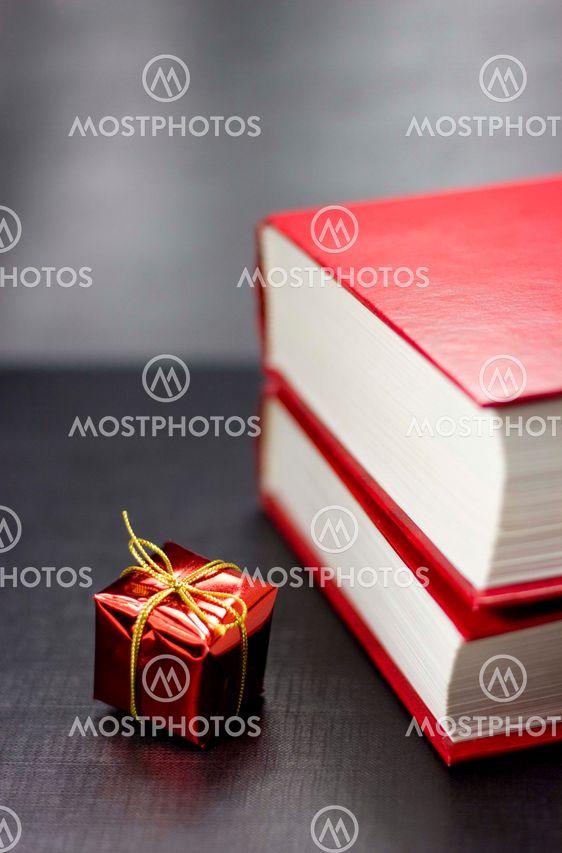 Two books and present on a black background