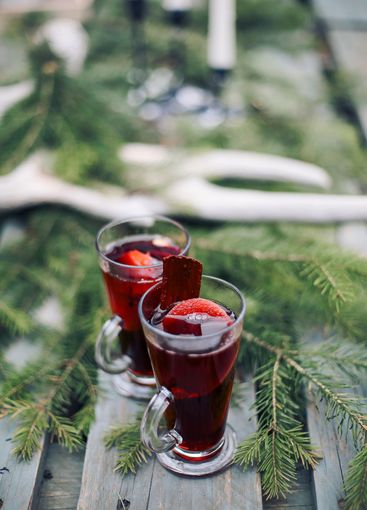 Hot mulled wine drink with citrus, apples, cinnamon sticks,