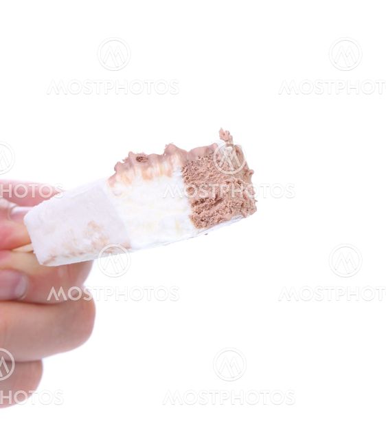 Hand holds bitten vanilla and chocolate ice cream.