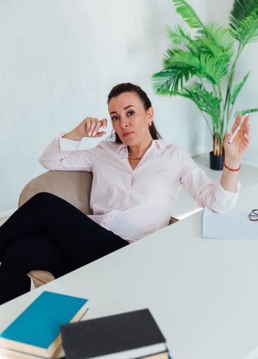Brunette businesswoman sitting at desk in office with...