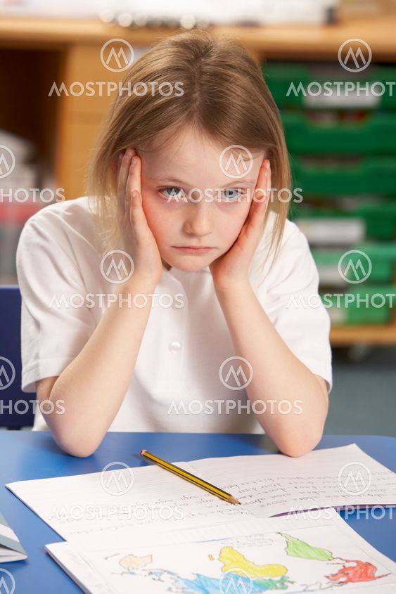 Stressed Schoolgirl Studying In Classroom