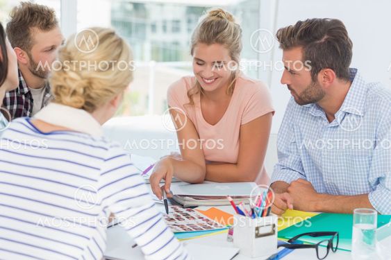 Smiling design team going over contact sheets at a meeting