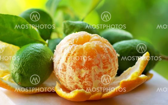 Peeled orange, and green lemons