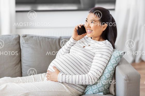 happy pregnant woman calling on smartphone at home