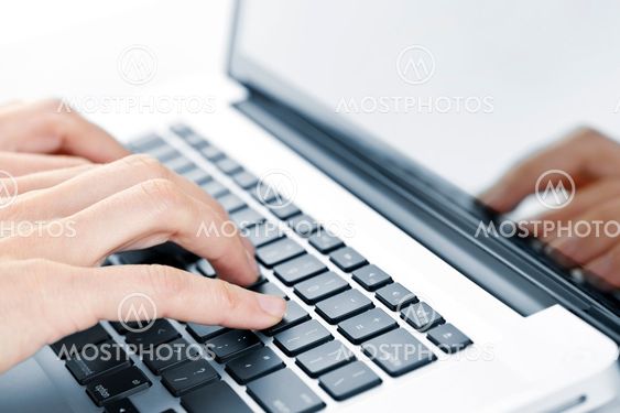 Hands typing on laptop keyboard