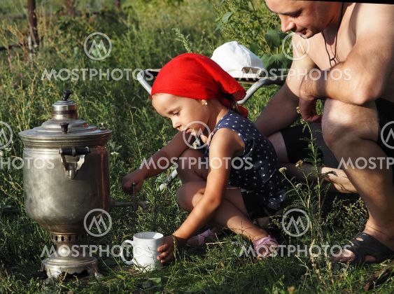 A little girl, while relaxing with her dad in nature,...