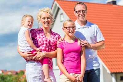 Family standing proud in front of home