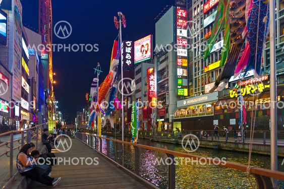 Osaka, Japan - April 2016: Tourist popular night shopping scene in Osaka City at Dotonbori Namba area with illuminated neon signs and billboards along the river