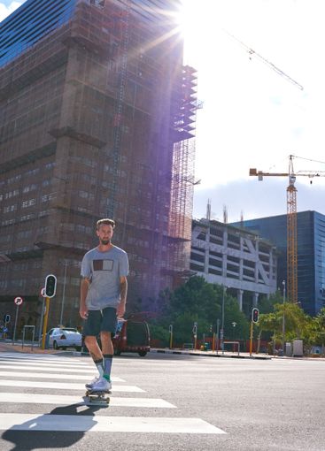 Man, skateboard and outdoor on crosswalk in street, low...