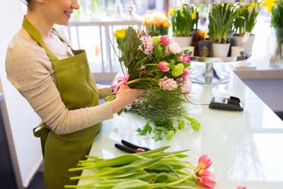 close up of woman making bunch at flower shop