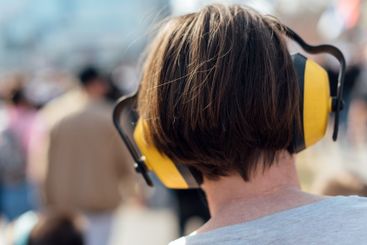 Female protester wearing earmuffs on the street during...