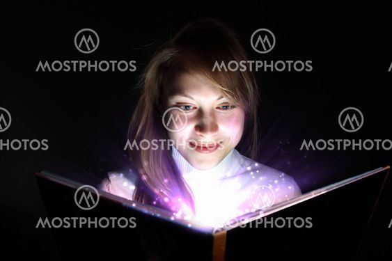 Young woman reading a magic book