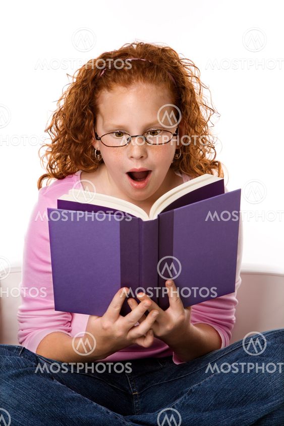 Girl reading book looking surprised.