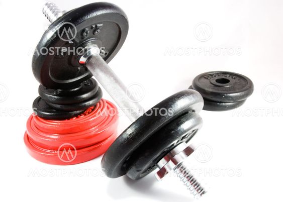 Dumbbell on stack of weights isolated on white