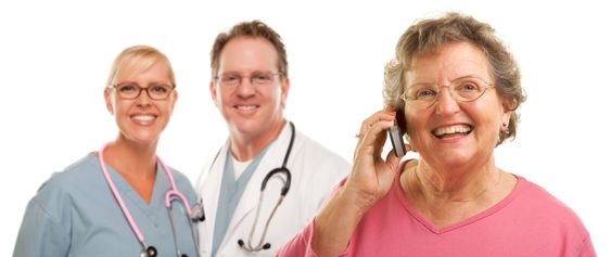 Happy Senior Woman Using Cell Phone and Doctors Behind