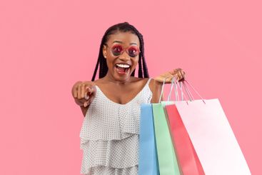 Seasonal sale or promo. Excited young black woman with...
