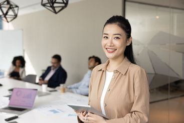 Happy beautiful young Asian project leader woman posing...