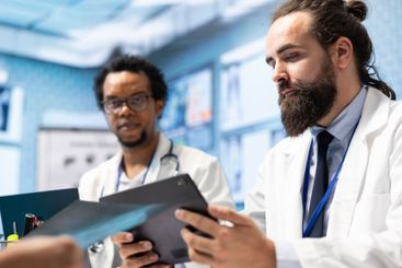 Doctors and medical staff focus on x ray scans and test...