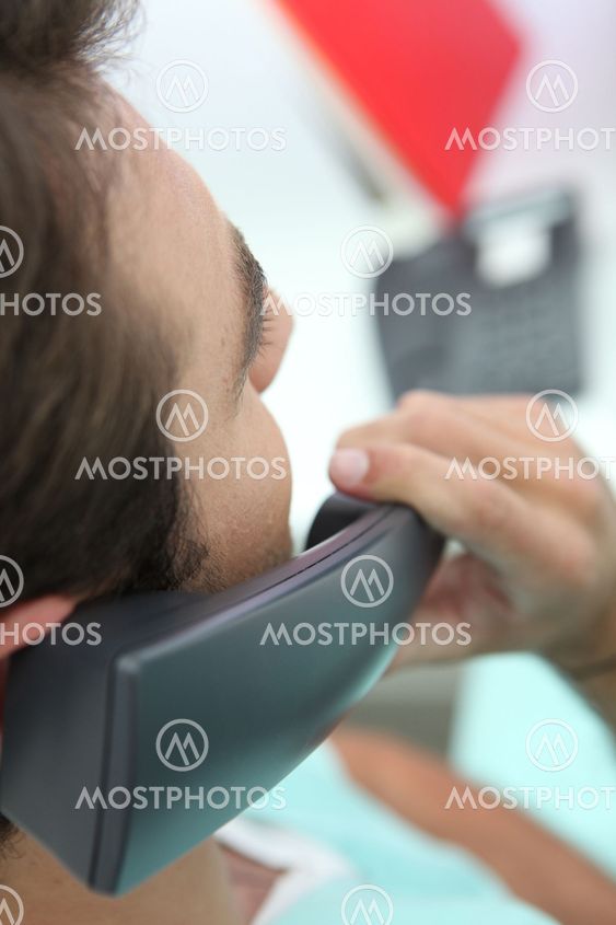 Artistic closeup shot of a man using a telephone