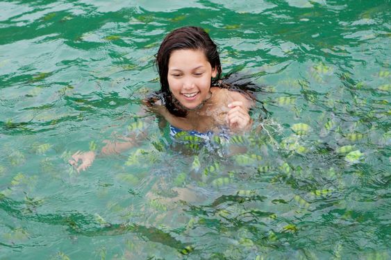 Girl swims with tropical fish