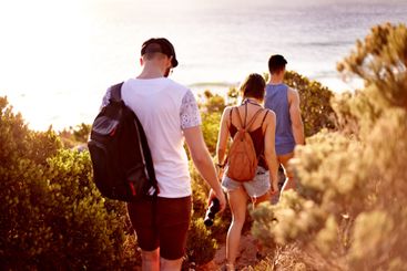Walking, travel and group of people by beach for...