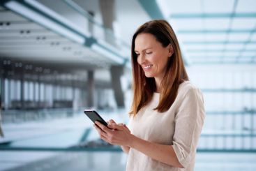 The European businesswoman multitasks on her smartphone