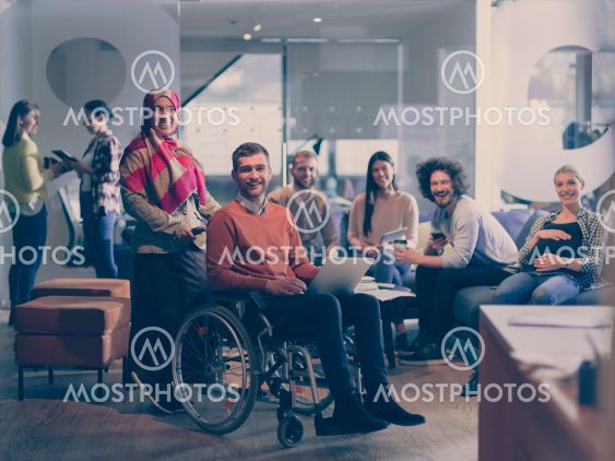 Disabled businessman in a wheelchair at work in modern...