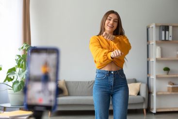 Young Caucasian female influencer recording video on...