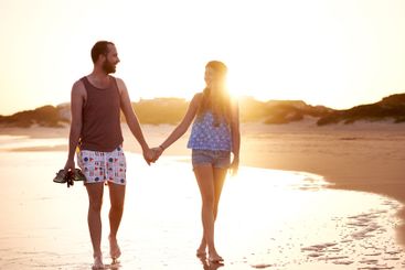 Couple, sunset and holding hands at beach together for...
