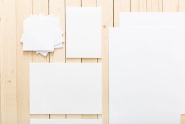 Blank sheets of paper arranged on a wooden table for...