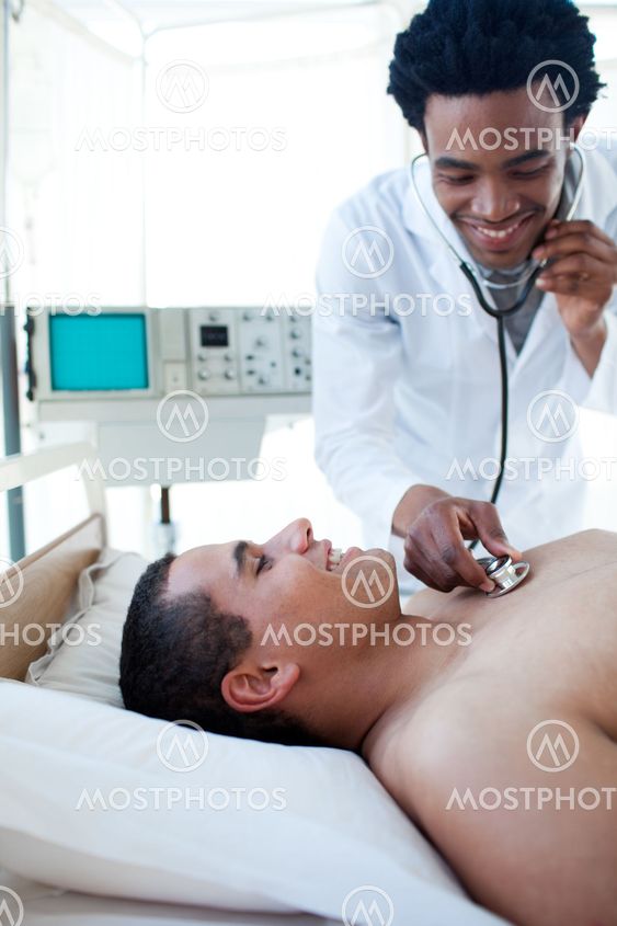 Smiling doctor checking the pulse on a male patient