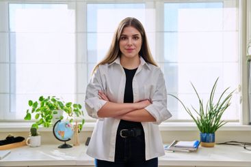 Portrait of young confident smiling woman in home interior
