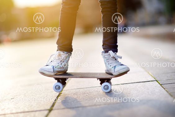 Closeup of skateboarder legs. Kid riding skateboard...